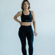 Woman wearing black high-waisted gym leggings and sports bra for training