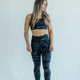 Woman wearing camo high-waisted gym leggings and black sports bra for training