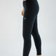 Person wearing black leggings with a logo on a white background